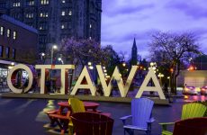 Tourists are taking pictures with the Ottawa sign installed at Inspiration Village. It's known for its colorful street art and trendy stores in Ottawa,Canada.